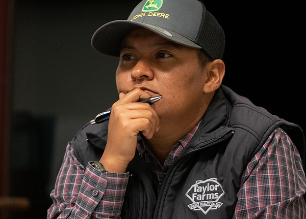 Man rubs chin while also holding a pen in his hand